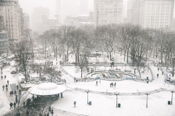 Snowy winter scene with trails left by pedestrians in the snow in Union Square as a blizzard overtakes New York City
