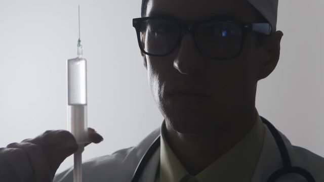 Portrait of a doctor with a syringe. An injection