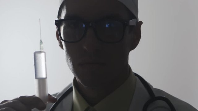 Portrait of a doctor with a syringe. An injection