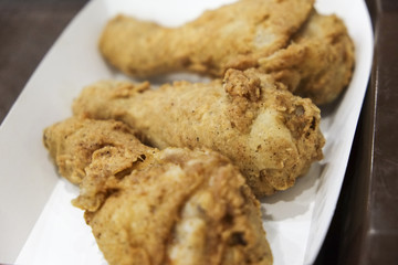 Crispy fried chicken drumsticks on paper plate