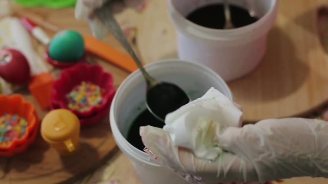 The girl decorates Easter eggs in a solution.Close-up