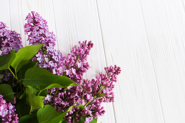 Lilac flowers on the wooden table. Greeting card.