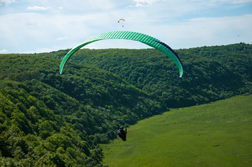 Paragliding over the river valley in summer sunny day. Dniester river, Ukraine.