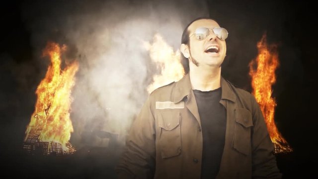 A tough-looking military man rising from the darkness, surrounded by burning fire and smoke clouds: dream, Vietnam, smell of napalm, war, warmonger.
