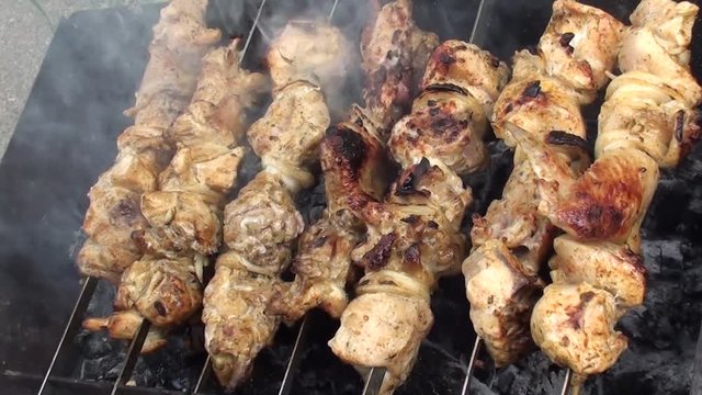 Smoking chicken on grill nearly ready, a hand sprinking water, zoom in 
