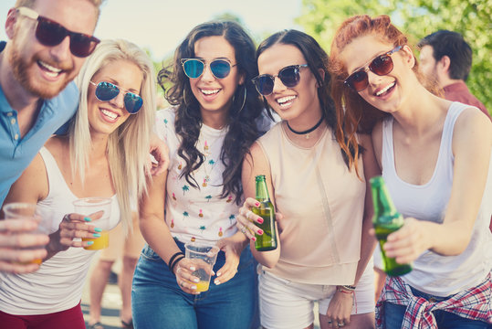 Group of people smiling, drinking, laughing and having a good time at the party