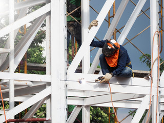 Construction workers working on scaffolding, Man Working on the Working at height with blue sky at...