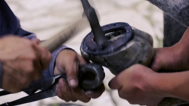 trimming, cleaning, shaping and cutting the excess sole tissue off the horse's hooves using knife in blacksmith shop. Horseshoe maker horseshoeing the horse. Azerbaijan