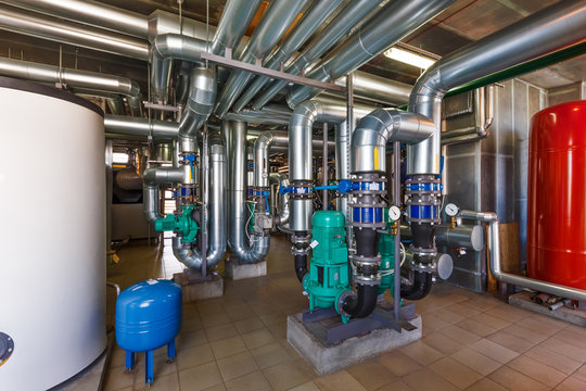 The interior of a modern gas boiler house with pumps, valves, a multitude of sensors and barrels