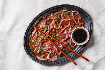 Asian style Beef carpaccio with soy sauce, chive onion, black sesame, served on vintage metal tray...