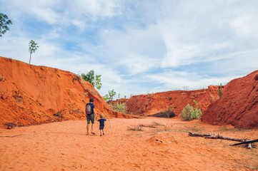 Father and son travelers in red canyon near Mui Ne, southern Vietnam. Traveling with children concept