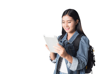 Portrait of a joyful asian woman using tablet in the studio while carrying a backpack, isolated on white background, 20-28 year old.