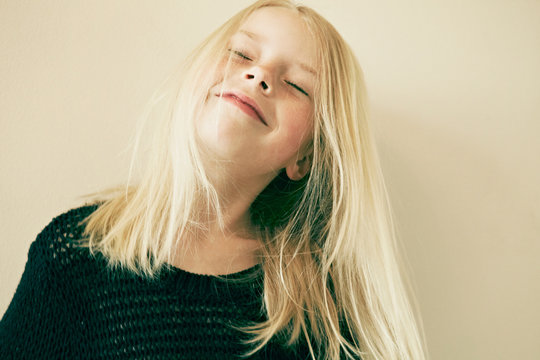 Young girl smiling with eyes closed, close up