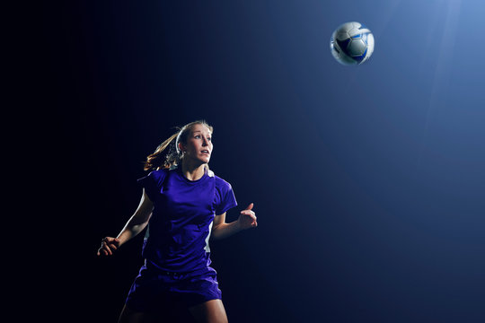 Young female soccer player heading ball