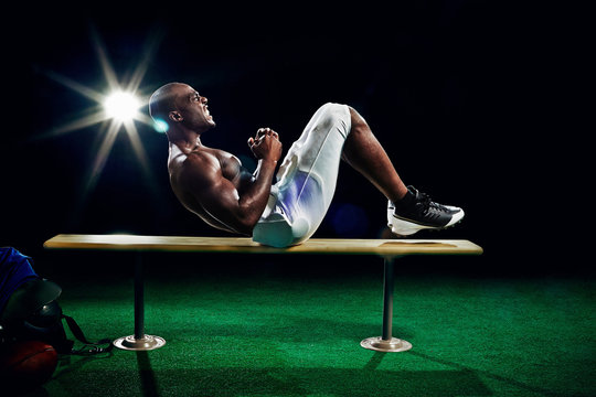 Portrait of american football player doing sit ups
