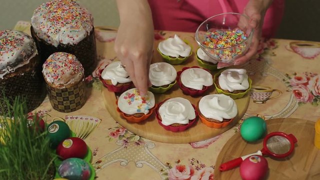 Girl sprinkles a candy decorated with muffins