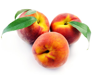 Fresh peach with green leaf isolated on white background.