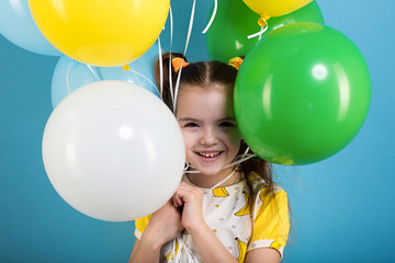 Little girl with baloons on blue background