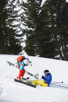 Skier helping another up