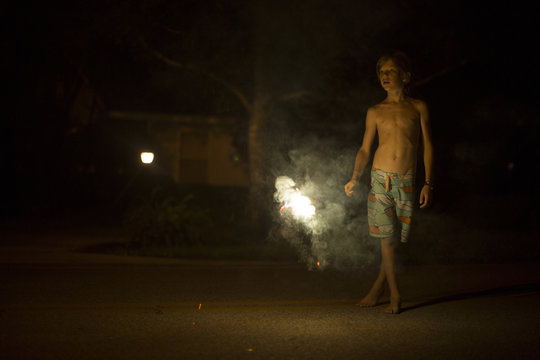 Portrait of boy at night with fireworks in background Destin, Florida, USA
