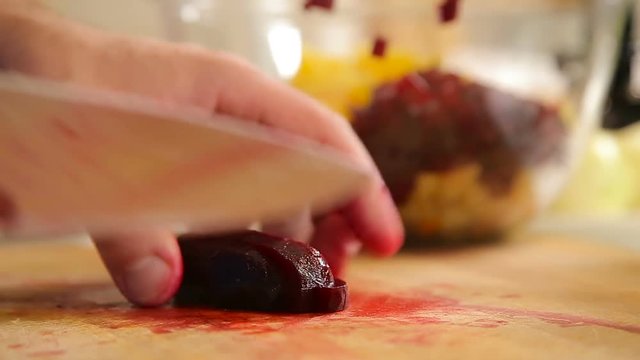 Cutting boiled beetroot on a wooden board