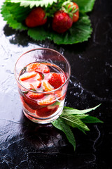 Strawberry mint detox water in glass on black background. Diet. Close up.