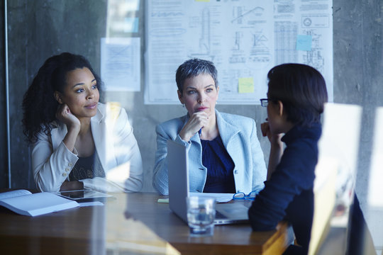 Three businesswomen discussing ideas in boardroom