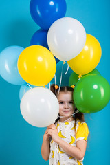 Fototapeta na wymiar Little girl with baloons on blue background