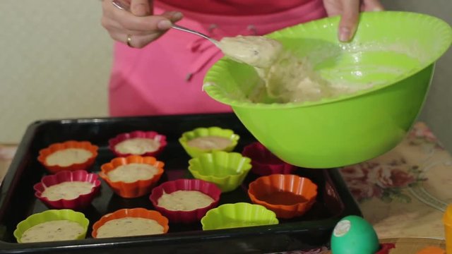Girl pours batter into cupcake molds
