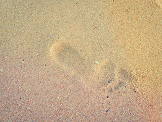 Natural background of human footprint in the wet sandy seaside. Close-up photography on relaxation sign idea design
