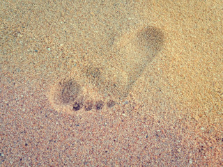 Natural background of human footprint in the wet sandy seaside. Close-up photography on relaxation sign idea design