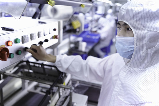 Worker using machinery in ecigarette factory