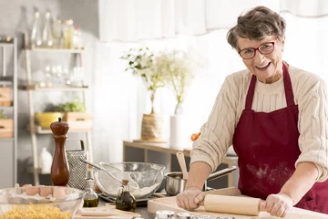 Crédence de cuisine en verre imprimé Cuisinier Senior woman rolling pizza dough