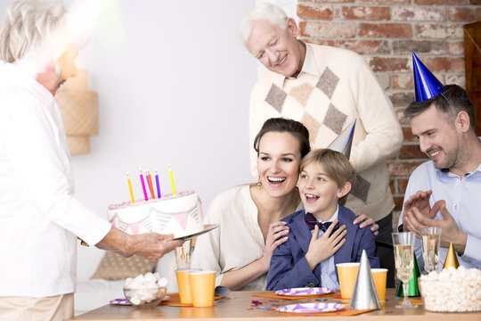 Grandma bringing birthday cake to a party