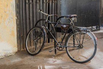 Obraz na płótnie Canvas Retro bicycle in the parking lot near the house