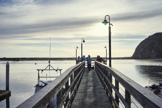 Fototapeta Small group of fishermen fishing from pier, Morro Bay, California, USA