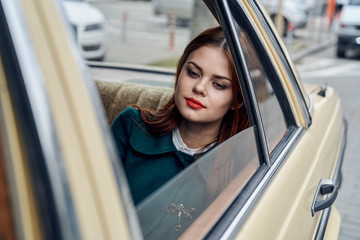 Woman with an open window of a car, a woman is sitting in the car