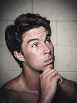 Portrait of young man posing with hand on chin after workout
