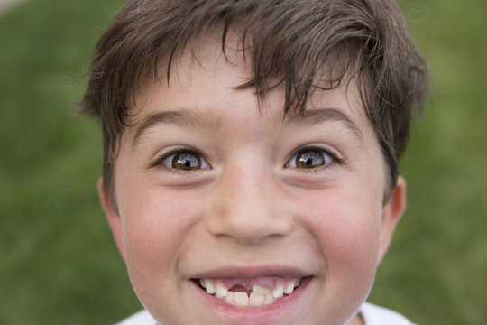 Portrait of young boy smiling, showing gap from lost tooth