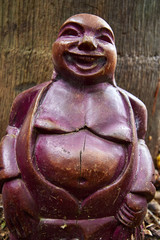 Red buddha status by coconut tree