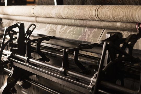 Roll of lace on old weaving machine in textile mill