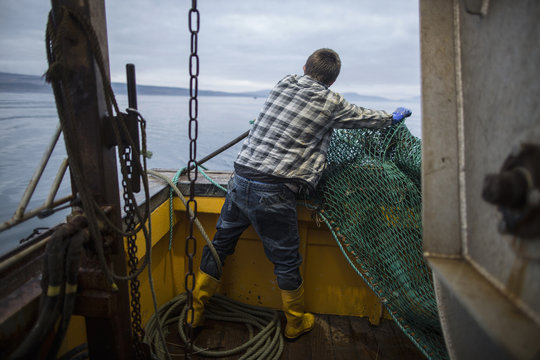 Fisherman preparing net, Isle of Skye, Scotland