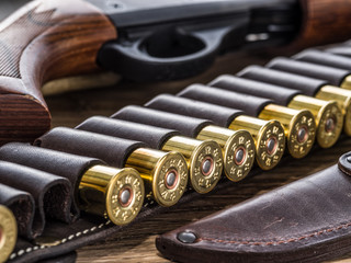 Obraz na płótnie Canvas Pump action shotgun, 12 guage cartridge and hunting knife.