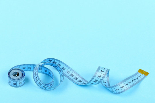 Roll Of Blue Tape Measure Untwisted On Turquoise Background