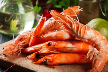 Selection of shrimp ready for frying with onion, garlic, chili and lime on cutting board