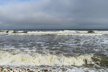 Landscape with sea view, waves and sea shells, clouds, photographed in Gura Portitei, Romania, in cloudy spring day