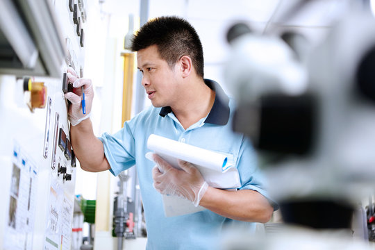 Man at control panel in flexible electronics plant