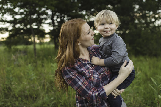 Mother holding young son in field