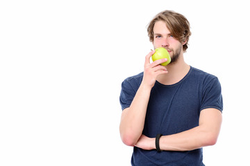 Sexy macho in blue tshirt with thoughtful face holds apple