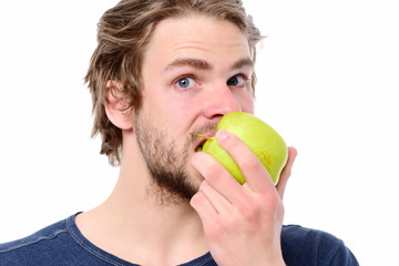 Young man in blue tshirt biting big green apple